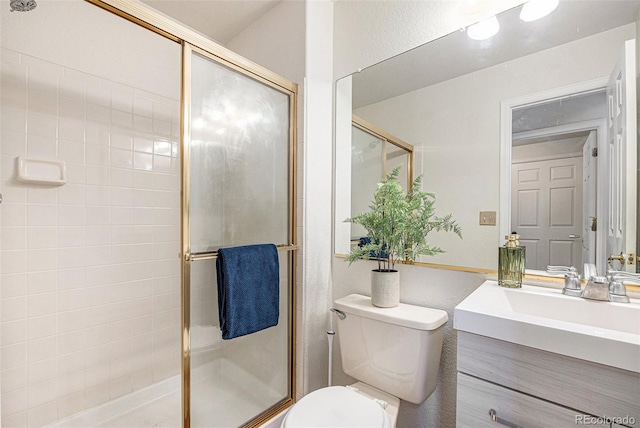 bathroom featuring a shower stall, toilet, and vanity