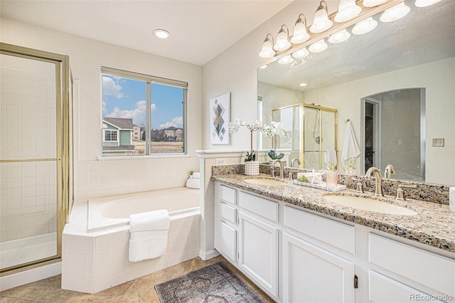 full bathroom featuring a garden tub, a sink, a shower stall, and double vanity