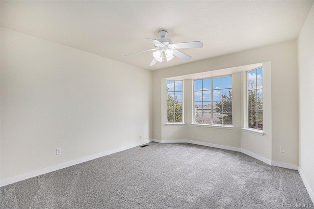 empty room featuring baseboards, carpet, visible vents, and a wealth of natural light