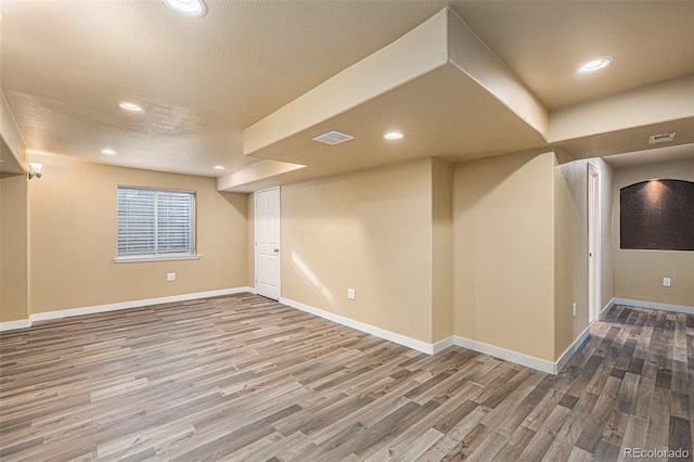 finished basement featuring recessed lighting, visible vents, baseboards, and wood finished floors