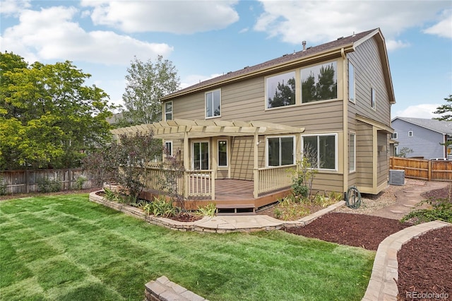 back of house featuring fence private yard, a deck, a pergola, and a yard