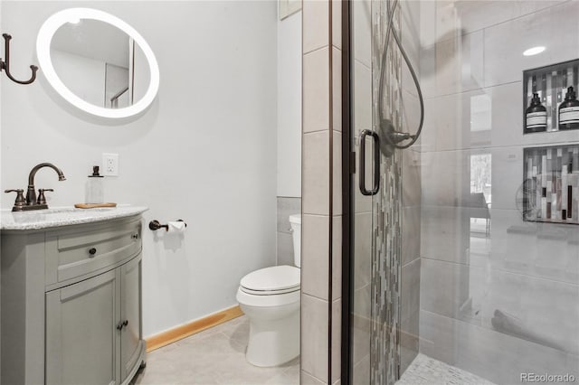 bathroom with tile patterned floors, vanity, toilet, and a shower with door