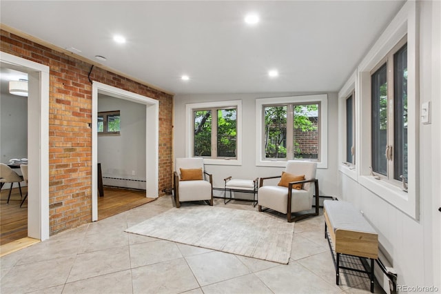 sitting room with brick wall, light tile patterned floors, and baseboard heating