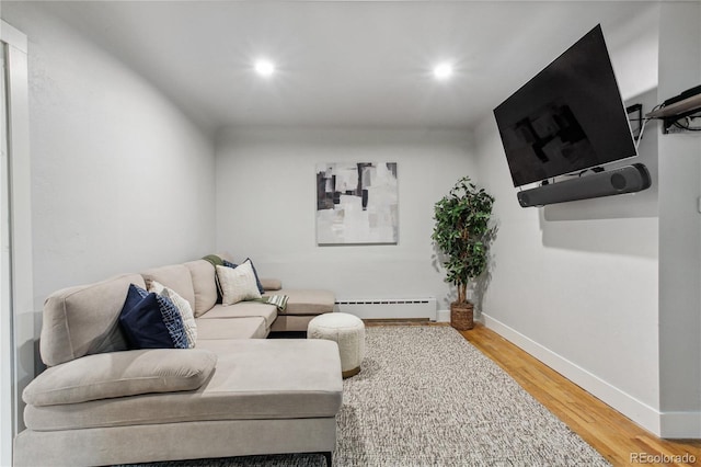 living room featuring a baseboard heating unit and wood-type flooring