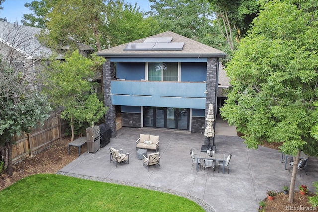 rear view of house featuring an outdoor hangout area, a patio area, and solar panels