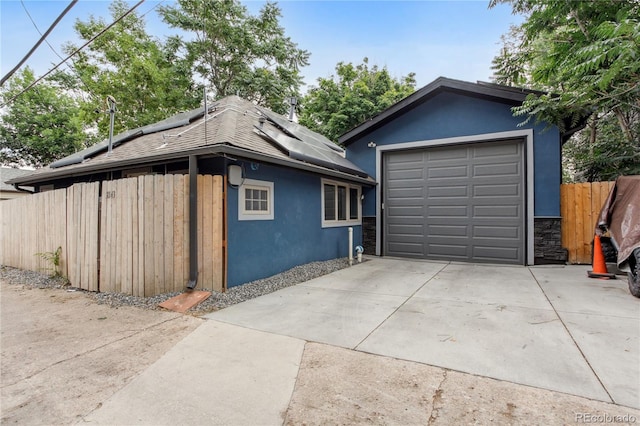 view of home's exterior featuring a garage, an outdoor structure, and solar panels