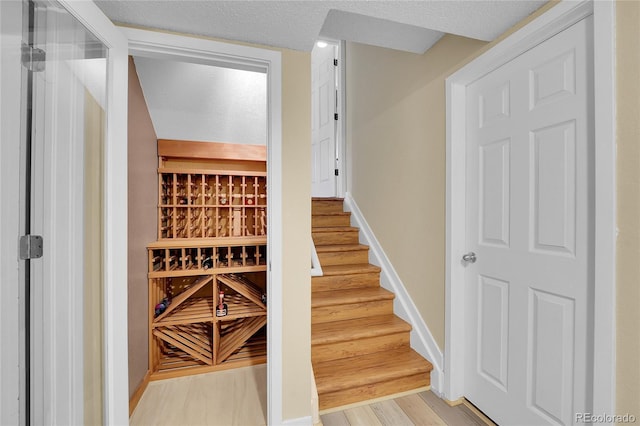wine room with light wood-type flooring and baseboards