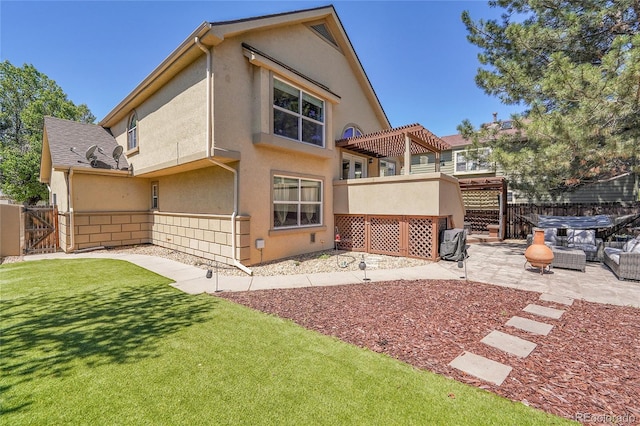 back of house featuring a pergola, a patio, stucco siding, and an outdoor hangout area