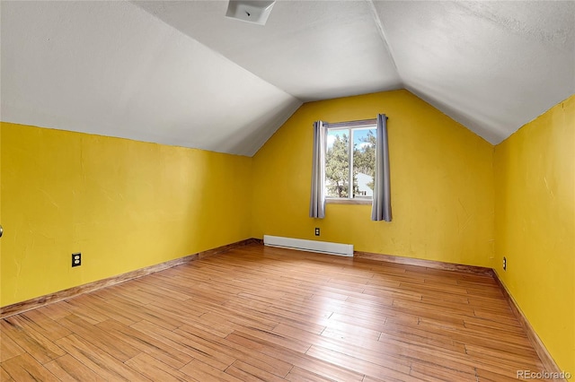64 Elk Horn Ct, Bailey, CO 80421 - bonus room featuring vaulted ceiling, baseboards, a textured ceiling, light wood finished floors, and baseboard heating