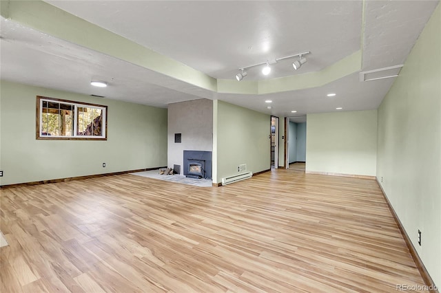 64 Elk Horn Ct, Bailey, CO 80421 - unfurnished living room with baseboards, track lighting, a baseboard heating unit, and light wood-style floors