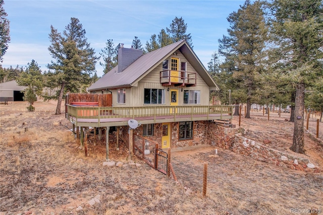 64 Elk Horn Ct, Bailey, CO 80421 - rear view of house with stone siding, metal roof, a deck, and a chimney