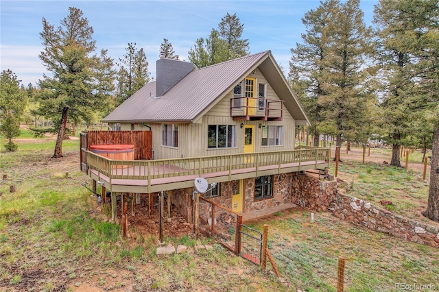 64 Elk Horn Ct, Bailey, CO 80421 - back of property with a balcony, a hot tub, a wooden deck, a chimney, and metal roof