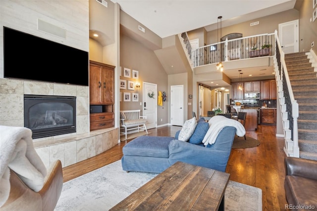 248 Writers Way, Colorado Springs, CO 80903 - living area featuring stairway, a tile fireplace, dark wood finished floors, and a towering ceiling