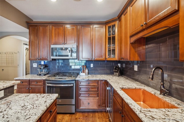 248 Writers Way, Colorado Springs, CO 80903 - kitchen with stainless steel appliances, backsplash, wood finished floors, and glass insert cabinets
