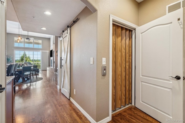 248 Writers Way, Colorado Springs, CO 80903 - hallway with a barn door, dark wood-type flooring, a textured wall, recessed lighting, and arched walkways