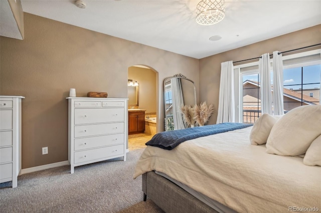 248 Writers Way, Colorado Springs, CO 80903 - bedroom with access to outside, arched walkways, light carpet, and ensuite bath