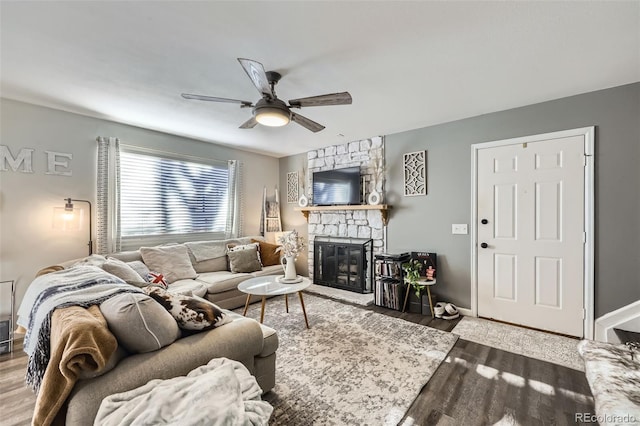 living room featuring ceiling fan, a fireplace, and hardwood / wood-style floors