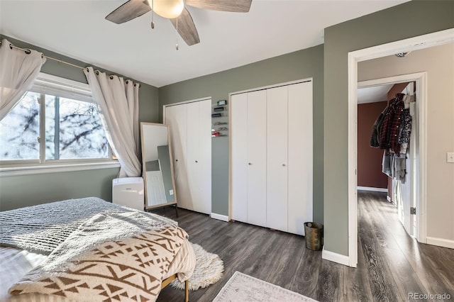 bedroom featuring ceiling fan, multiple closets, and dark hardwood / wood-style flooring