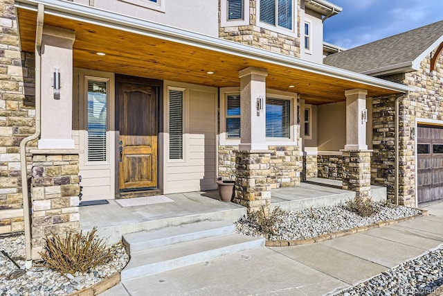 view of exterior entry with a garage and covered porch