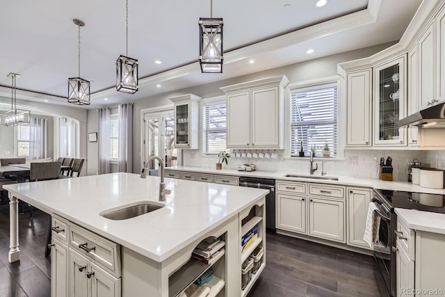 kitchen featuring sink, a center island with sink, electric range, and a raised ceiling