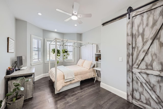 bedroom featuring dark wood-type flooring, ceiling fan, and a barn door