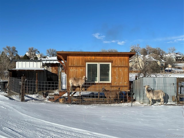 view of snowy exterior featuring an outdoor structure