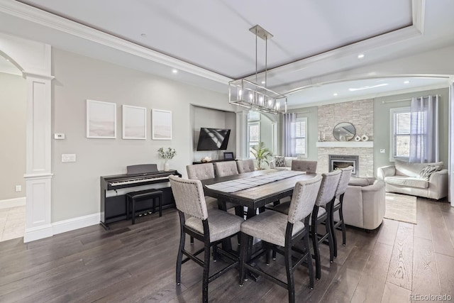 7587 Wright Ct, Arvada, CO 80005 - dining room featuring ornate columns, dark wood-style floors, recessed lighting, a tray ceiling, and crown molding