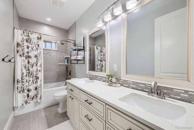 7587 Wright Ct, Arvada, CO 80005 - full bath featuring toilet, double vanity, shower / bath combo with shower curtain, tasteful backsplash, and baseboards
