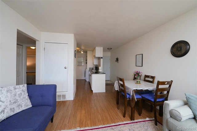 dining area with visible vents and light wood-style flooring
