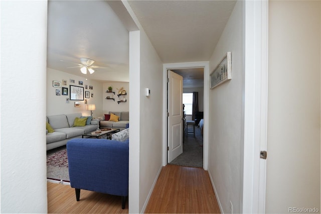 hall with wood finished floors and baseboards