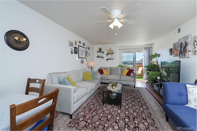 living area featuring ceiling fan, visible vents, and wood finished floors