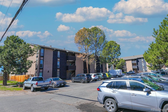 view of property featuring uncovered parking and fence