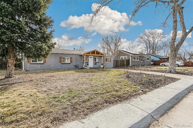 view of front of home featuring stucco siding and fence