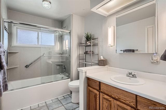 full bathroom with enclosed tub / shower combo, vanity, tile patterned floors, and toilet