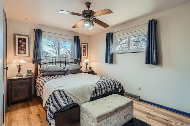 bedroom featuring multiple windows, ceiling fan, and light hardwood / wood-style flooring