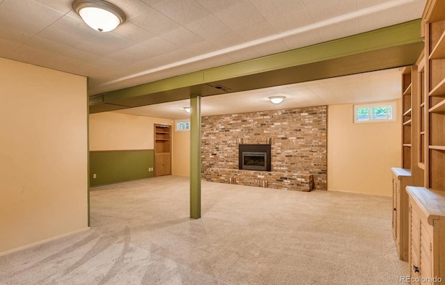 basement featuring light carpet and a brick fireplace