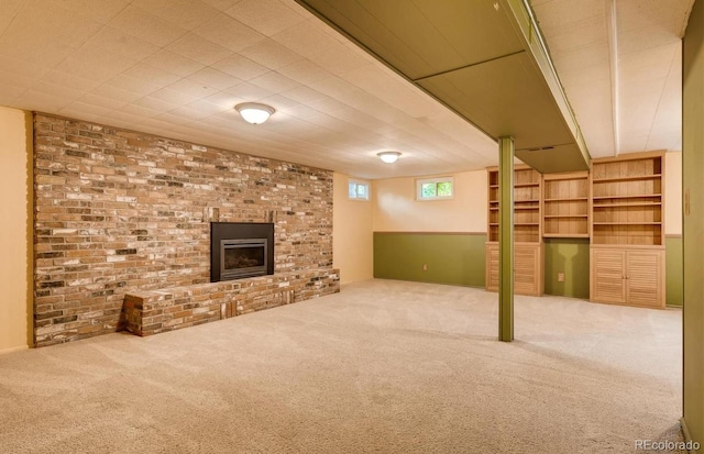 basement with a fireplace, brick wall, and carpet flooring