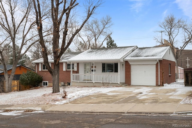 ranch-style home featuring an attached garage, covered porch, concrete driveway, and brick siding