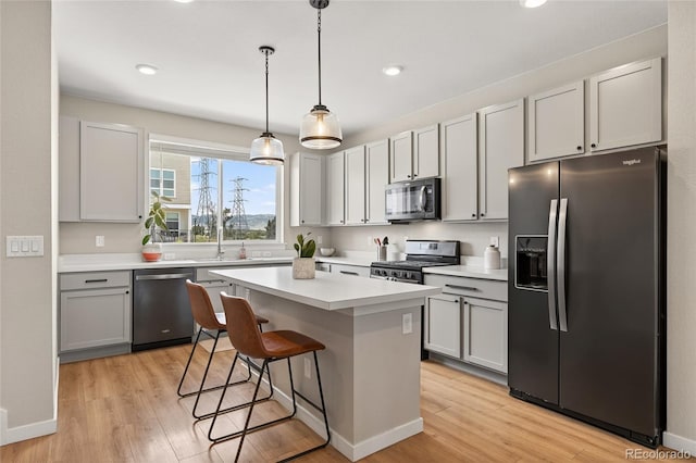5396 Quail St, Wheat Ridge, CO 80033 - kitchen featuring stainless steel appliances, light wood-style floors, a breakfast bar, a center island, and recessed lighting