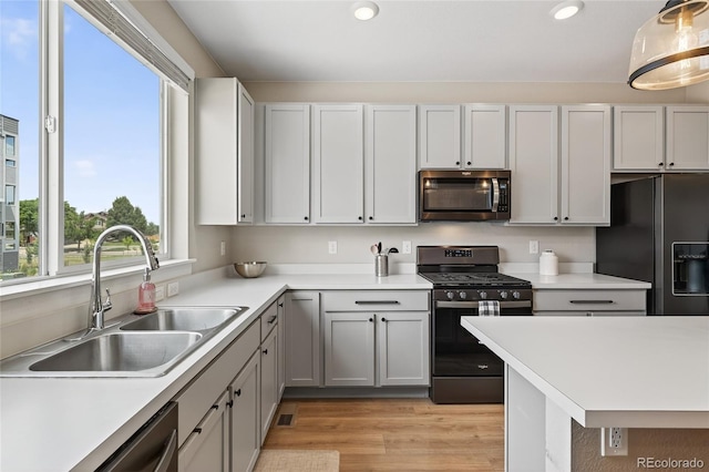 5396 Quail St, Wheat Ridge, CO 80033 - kitchen with appliances with stainless steel finishes, light countertops, recessed lighting, light wood-style flooring, and decorative light fixtures