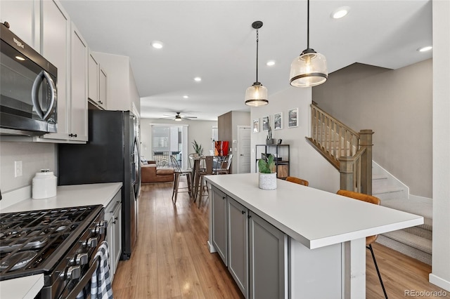 5396 Quail St, Wheat Ridge, CO 80033 - kitchen featuring gas stove, a ceiling fan, gray cabinetry, light countertops, and recessed lighting