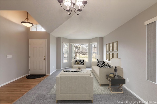 living room featuring hardwood / wood-style floors, a notable chandelier, and vaulted ceiling