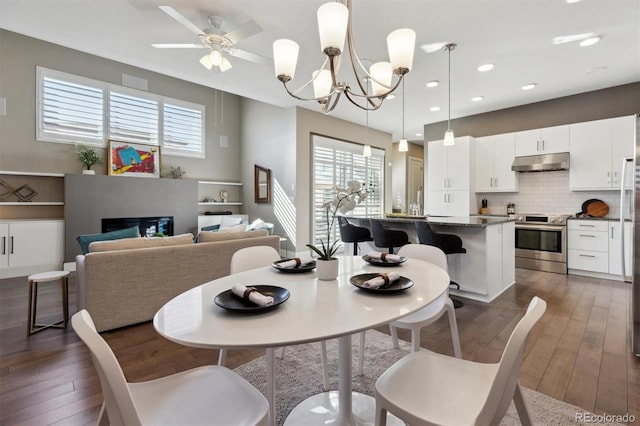 dining area featuring a glass covered fireplace, dark wood-style flooring, ceiling fan, and recessed lighting