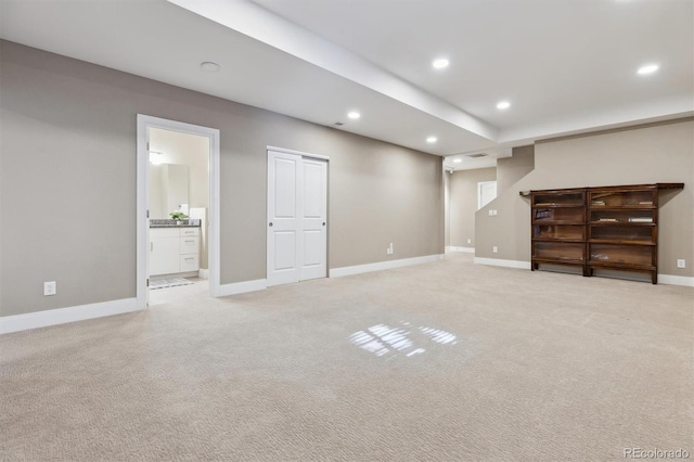 basement with light carpet, baseboards, and recessed lighting