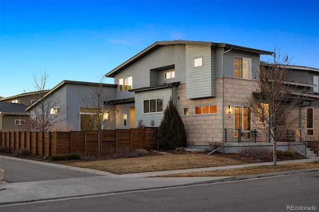 view of front of house featuring stone siding and a fenced front yard