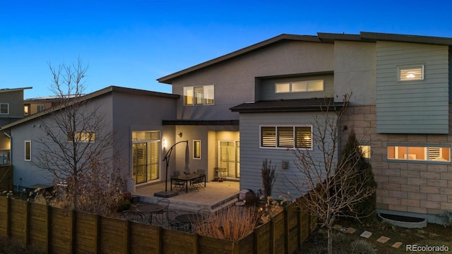 back of property featuring a patio, fence, and stucco siding