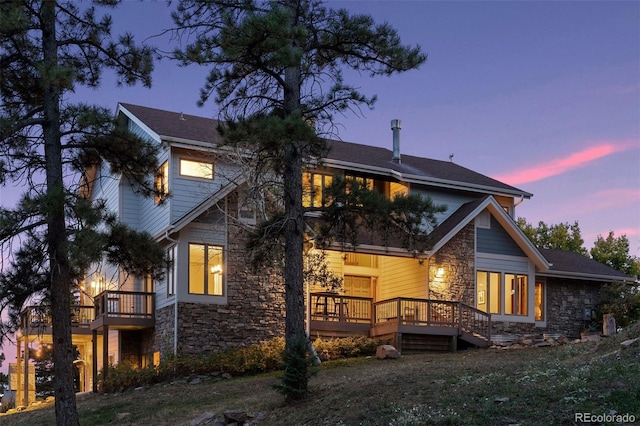 12421 High Country Trl, Littleton, CO 80127 - back of property at dusk with stone siding and a deck