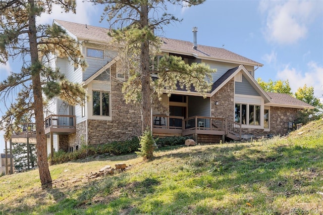 12421 High Country Trl, Littleton, CO 80127 - back of house featuring stone siding, a lawn, a wooden deck, and roof with shingles