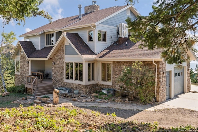12421 High Country Trl, Littleton, CO 80127 - view of front facade featuring stone siding, a shingled roof, driveway, a chimney, and ac unit