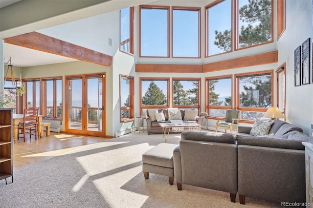 living room with light colored carpet, a high ceiling, and a wealth of natural light